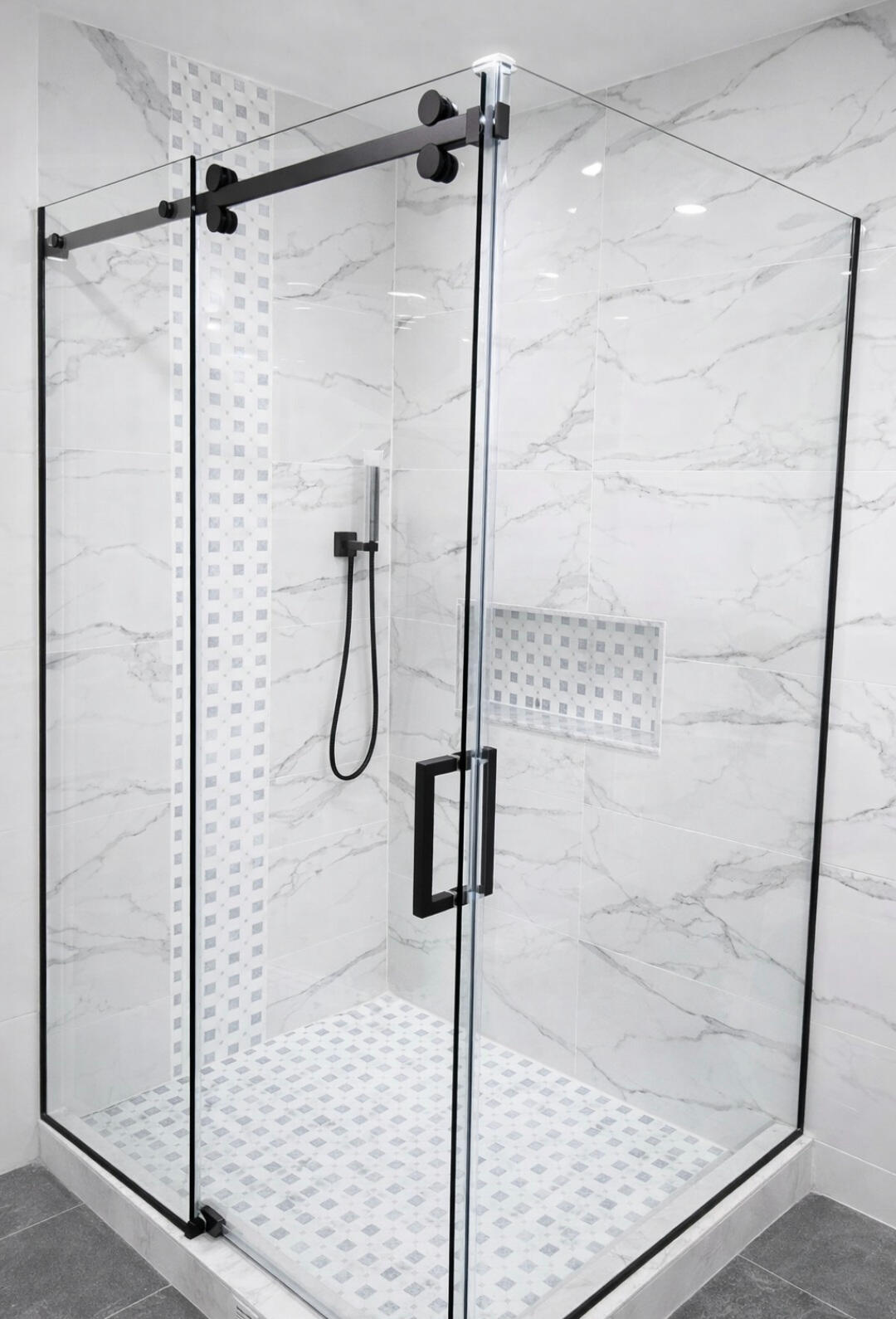 Frameless sliding glass shower door with black hardware installed by Crystal Vision Glass in New Jersey